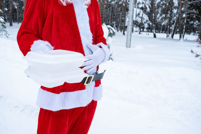 Rear view of woman standing on snow covered field