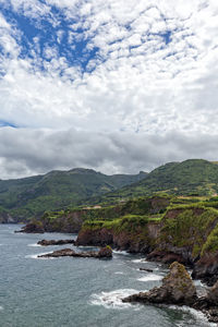 Scenic view of sea and mountains against sky