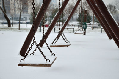 Several swings in city park covered with snow