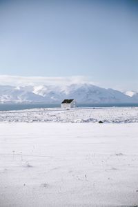 Scenic view of sea and snowcapped mountains against sky