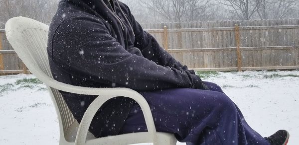Person sitting covered with snow