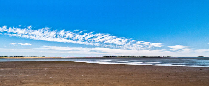 Scenic view of beach against blue sky