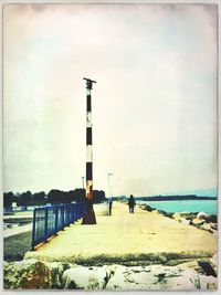 Lighthouse on sea against sky