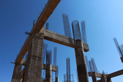 Low angle view of crane against clear blue sky