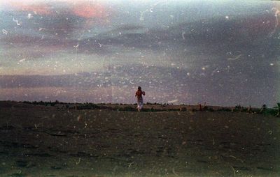 Man standing on field against sky at night