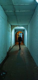 Rear view of man walking in tunnel