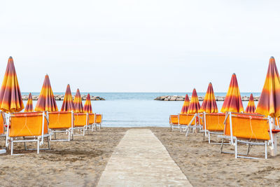 Sunbeds and parasols on the seashore. beach, sea and umbrellas on summer day.