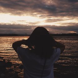Scenic view of sea against cloudy sky at sunset