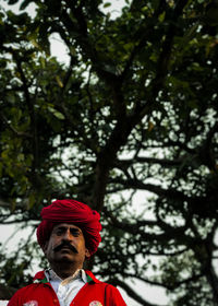 Low angle view of woman standing against trees