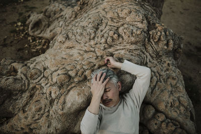 High angle view of man lying on rock