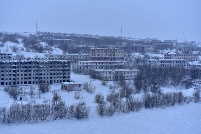 Snow covered buildings against sky