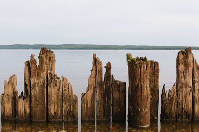 Panoramic view of wooden post on beach against sky