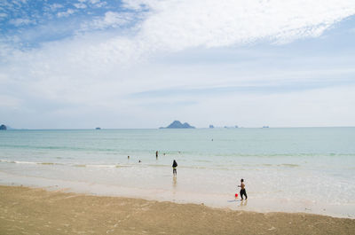 People standing on beach against sky