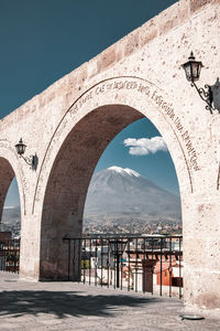 Arch bridge in city against sky