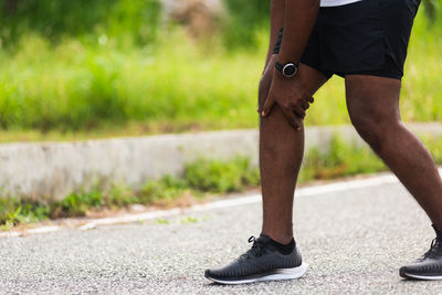 Low section of man standing on footpath