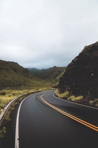 Road amidst mountains against sky