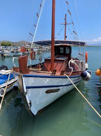 Sailboats moored in sea against sky