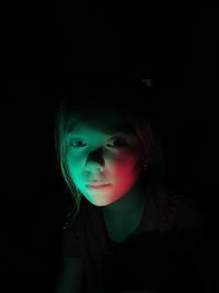 Close-up portrait of a child on a black background and with a play of light