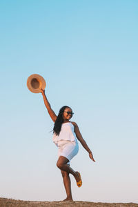 Rear view of woman standing against clear sky