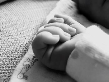 Close-up of baby hand on bed