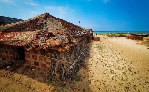 Abandoned building by sea against sky