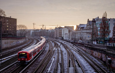 High angle view of train in city against sky during sunset