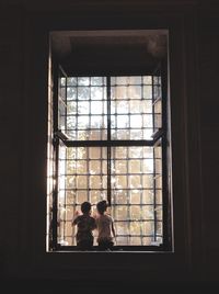 Boy and girl looking through window