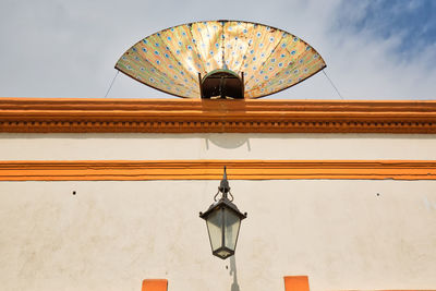 Low angle view of electric lamp against sky