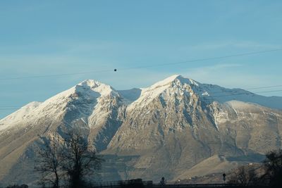 Low angle view of snow covered mountains against sky