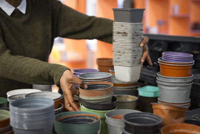 Midsection of woman picking up reused plant pots at recycling center