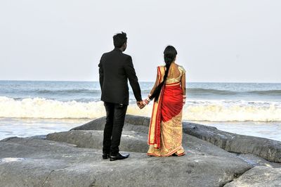 Rear view of people walking on beach