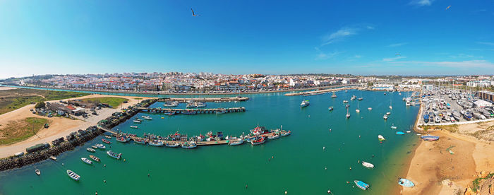 High angle view of townscape by sea against blue sky