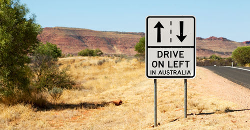 Information sign on road against sky