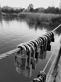 Close-up of padlocks on railing against river