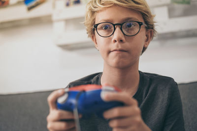 Close-up of cute boy playing video game at home