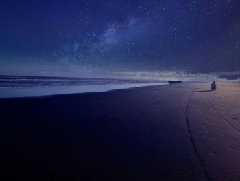 Scenic view of beach against star field at night