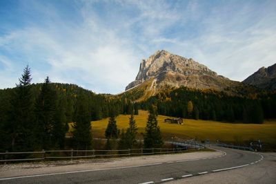 Road by mountains against sky