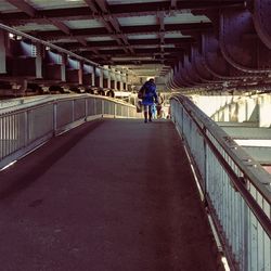 Rear view of woman walking on bridge