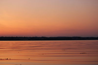 Scenic view of lake against orange sky