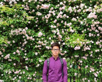 Portrait of young woman standing on purple flowers