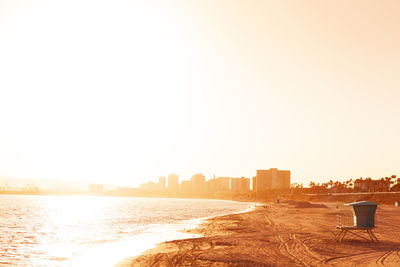 Scenic view of sea and buildings against clear sky