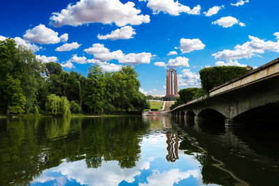 Bridge over river against cloudy sky