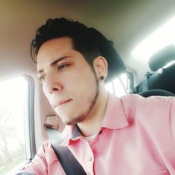 Portrait of young man sitting in car