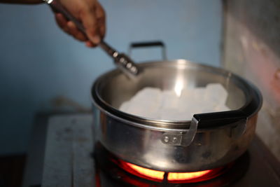 Cropped hand of person preparing food at home