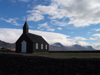 Scenic view of church against cloudy sky