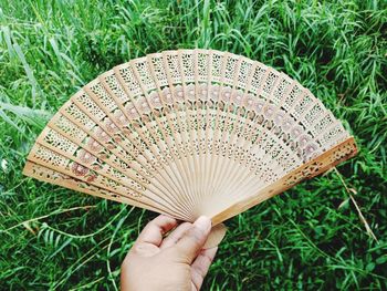 Close-up of person hand holding hand fan