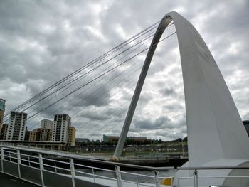 Low angle view of bridge against cloudy sky