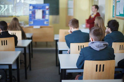 Rear view of students sitting in classroom