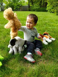 High angle view of cute baby boy sitting on grassy field