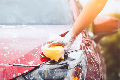 Cropped image of hand washing car